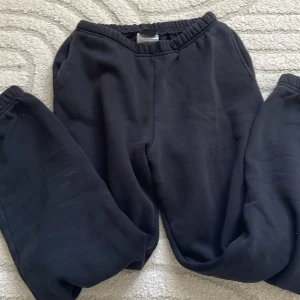 Svarta mjukisbyxor från Gina Tricot - Svarta mjukisbyxor från Gina Tricot i storlek XS. Byxorna har resår i midjan och är gjorda i mjukt material som känns skönt mot huden. Perfekta för chill dagar eller när du vill vara extra bekväm.