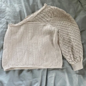 Stickad tröja - Säljer en beige stickad oneshoulder-tröja från MNG. Bra skick