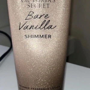 Victoria's Secret Bare Vanilla Shimmer - Glittrande shimmer lotion från Victoria's Secret i doften Bare Vanilla. Ger huden en skimrande finish med en mjuk vaniljdoft. Perfekt för att highlighta kroppen och få extra glow. Kommer i en snygg guldig tub med glittereffekt. Den har aldrig använts och nypris tror jag var 300kr