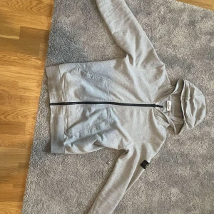 Stone island - Grå stone island zip hoodie i mycket bra skick, storlek 12 (junior storlek), säljs åt en vän, hör av dig vid minsta intresse!