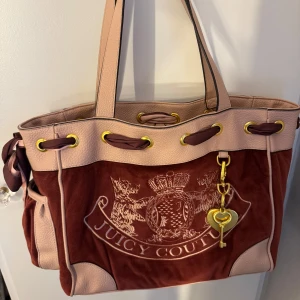 Juicy Couture daydream bag - Säljer en skit snygg väska från juicy couture som inte används längre, den är använd fåtal gånger och har ytterst få defekter som längst upp på banden så har det blivit märken från där jag hängt upp väskan på, och lite på spegeln. Men inget som märks jätte mycket.  Hör gärna av er om ni skulle ha några  funderingar💓