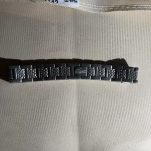 Silverfärgad länkarmband från Lacoste - Säljer ett silverfärgat länkarmband från Lacoste med klassisk krokodil-logga på mittenlänken. Armbandet har en stilren design med texturerade detaljer på länkarna. Perfekt som utbytbar länk till din Lacoste-klocka. Oanvänd, helt fast pris det är bra pris för kvaliten.