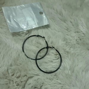 Svarta stora hoops örhängen - Stora svarta hoops / creoler.  örhängen med enkel och clean design. Cirka 6 cm i diameter. 316L kirurgiskt stål. Helt nya och oanvända,  endast uttagna för att ta bilder.