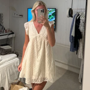 Vit kortklänning med v-ringning - Supersöt vit kortklänning med v-ringning och volangärmar.🥰aldrig använd 