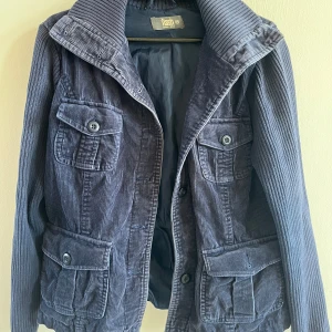 Blå manchesterjacka  - Snygg blå manchesterjacka med fyra stora fickor framtill och coola knappar. Jackan har bred krage och långa ärmar i samma ribbade manchestertyg.   Den är min mammas gamla