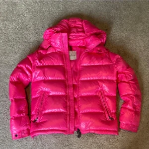 Rosa Moncler dunjacka - Säljer en riktigt snygg och glansig rosa dunjacka från moncler i storlek xs, den har inga defekter 