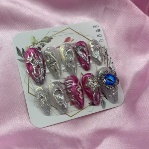 StarlightCurs3(S);Medium Almond - Snygga gelé press-on naglar i metallic silver och glansig rosa med 3D-effekter, stjärndekor och en blå kristalldetalj. Naglarna har almond form och coola detaljer i silver, perfekt för dig som vill sticka ut med din nagelstil. I storlek S: 15 mm, 11,5 mm, 12 mm, 11 mm, 9 mm 