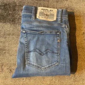 Blå jeans från Replay - Snygga blå jeans från Replay med klassisk femficksdesign och en diskret logga på bakfickan. Jeansen har en knappgylf och är tillverkade i ett slitstarkt denimtyg. Perfekta för en avslappnad stil.