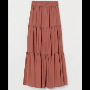 Bronze långkjol med volang - H&M - Säljer en bronze långkjol med elastisk midja och flera volanger. Endast använd ett fåtal gånger. Köpte för 299kr säljer för endast 150kr