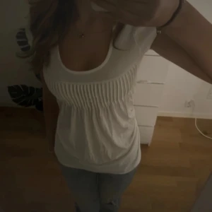 Tunika  - stilren vit topp med rund halsringning och smockdetaljer. perfekt inför våren 💞jag är 172 o de är mina bilder (defekter: hål/slitningar i varierande storlek på mest bak men några få fram)