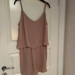 Beige/ Rosa playsuit från Vila - Helt ny playsuit från Vila med tunna axelband och ett löst fall. 