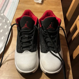 Nike Air Jordans i svart och vitt - Snygga Nike Air Jordans i svart och vitt med röda detaljer. Skorna har en klassisk design med snörning och en bekväm passform. Perfekta för både stil och komfort. Använda en gång 