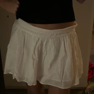 Vit kjol - Kjol från Gina barn storlek 170 men sitter typ som en S (xs och m funkar nog). Aldrig använd med lapp kvar. Den är vit med guldiga prickar 