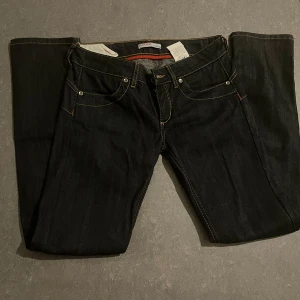Svarta jeans från Liu Jeans - Snygga svarta jeans från Liu Jeans med guldfärgade sömmar och dragkedja på bakfickan. Klassisk femficksdesign och jen stilren look som passar perfekt till många tillfällen.