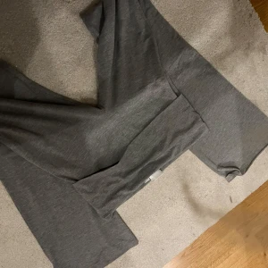 Grå yoga pants - Säljer ett par grå mjukisbyxor med en diskret stjärndetalj. Byxorna har en bekväm passform och är perfekta för en avslappnad stil. De är tillverkade i ett mjukt material som känns skönt mot huden.