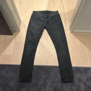 Svarta jeans från Dondup - Snygga svarta jeans från Dondup med en slim passform. De har en klassisk femficksdesign och knappar i midjan. Perfekta för en stilren look. Bra skick storlek 30! 