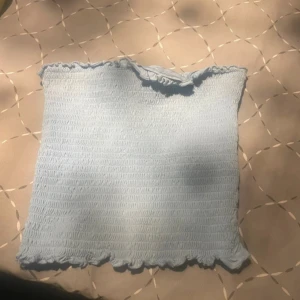 Ljusblå tubtopp från Amisu - Säljer en söt ljusblå tubtopp från Amisu. Toppen är elastisk med en smockad design och har en fin volangdetalj upptill och nertill. Perfekt för varma sommardagar! 💙
