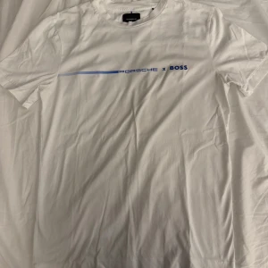 Vit t-shirt från Porsche x Boss - Snygg vit t-shirt från Porsche x Boss med blått tryck på bröstet. Aldrig andvänd. Köpt för 700 