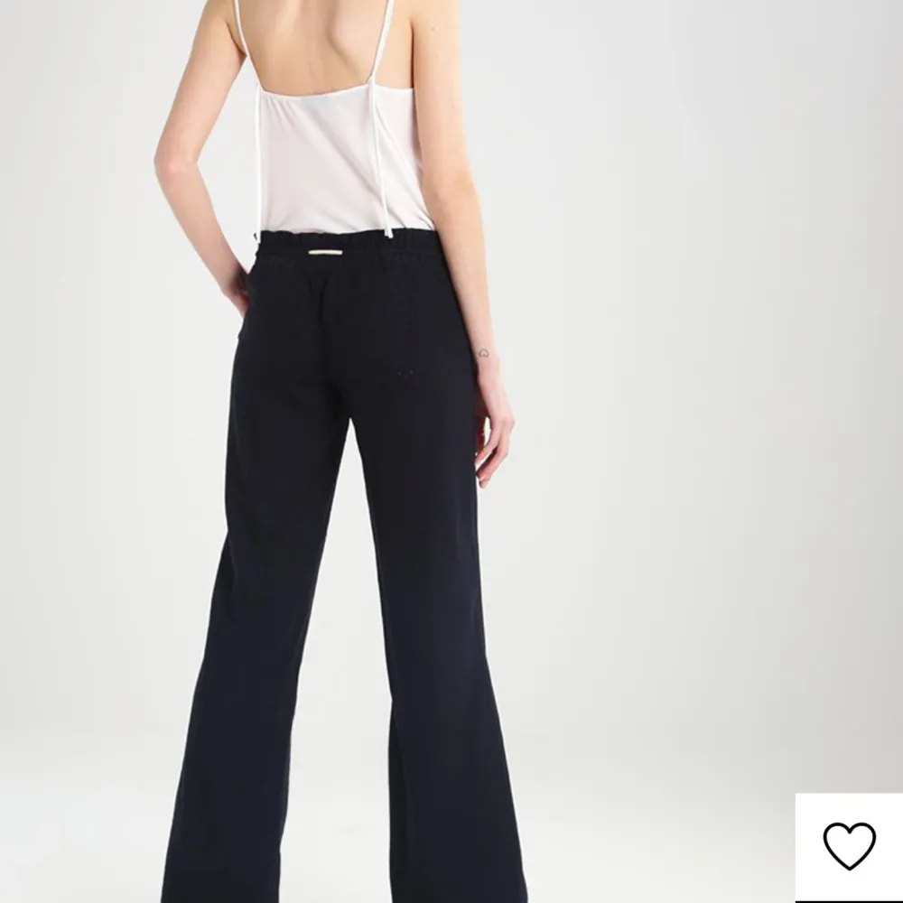 Snygga svarta linnebyxor från roxy med rak passform och låg midja. Perfekta för en stilren look. Tillverkade i ett bekvämt material som ger en skön känsla hela dagen.. Farkut & Housut.
