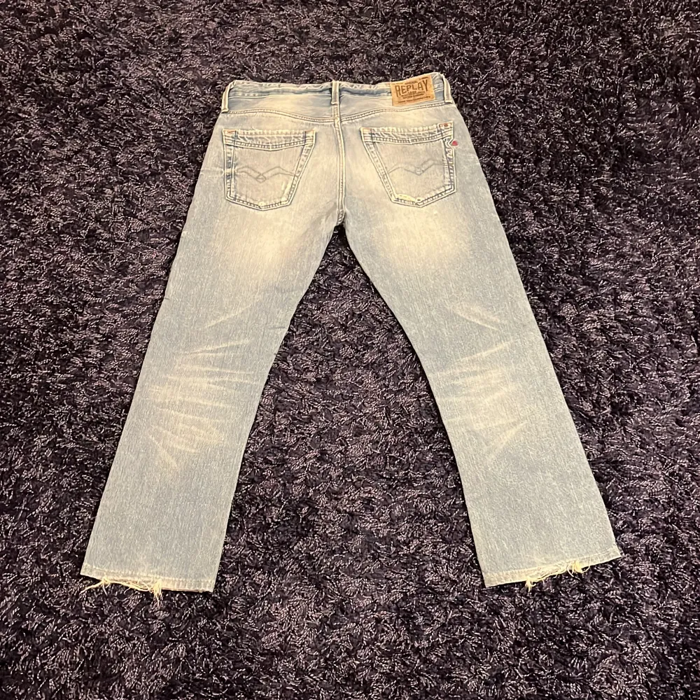 Säljer ett par ljusblå jeans från Replay med en klassisk femficksdesign. Jeansen har en straight passform och fransade benslut för en avslappnad look. Perfekta för en casual stil, det finns en defekt då lite stygn har gått av vid bakfickan. Hör av er vid minsta fundering🙌. Farkut & Housut.