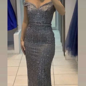 Glittrig silverfärgad långklänning - Säljer min klänning endast använd några timmar💕nypris 1300kr köpt för 2399kr. Storlek 36
