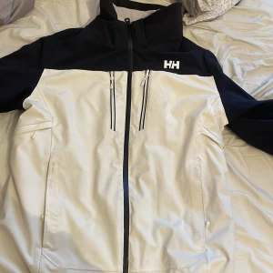 Svart och vit skidjacka från Helly Hansen  - Lite smutsig vid fickorna och lite på jackan därför priset. Hör av er vid frågor eller om ni vill ha fler bilder😀