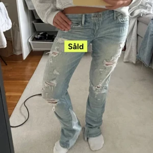 Ljusblå slitna jeans med bootcut - Ljusblå jeans med slitningar och hål på flera ställen. Modellen har bootcut och normal passform. Jeansen har klassisk femficksdesign och är tillverkade i denim. Perfekta för en avslappnad och trendig look. lånade bilder💕💕