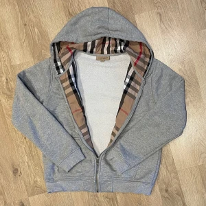Burberry zip-up - Först till kvarn!!!       Nypris: ca 3000-5000.        En snygg och mycket efterfrågad burberry zip-up. Storlek: L/G men passar som en Small ungefär Priset går att diskutera vid en snabb och smidig affär!          Det ser ut som att den är sliten vid slutet på ärmen men det blev bara något konstigt med skuggan!              