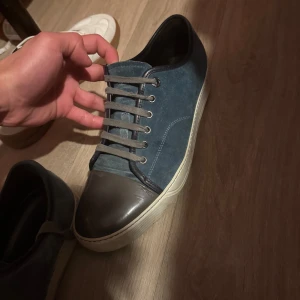 Blå sneakers från Lanvin med grå tå - Säljer ett par blå sneakers från Lanvin med grå tåparti och vit sula. Skorna är i ett bra skick, kan gå ner i pris vid snabb äffer, kontakta ifall du har några frågor :)   Jag uppstår för frakt! 