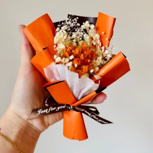 torkade blommor - en liten bukett med torkade blommor inslagna i orange och brunt papper. Buketten är dekorerad med ett brunt band med texten 'Just for you'