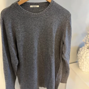 Grå stickad tröja från Crossley - Mysig grå stickad tröja från Crossley med rund halsringning och långa ärmar. Perfekt för lager-på-lager och enkel att matcha med olika outfits. Klassisk och stilren design. Nypris 999kr