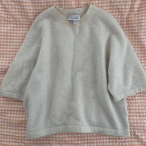 Cremevit stickad tröja  - Säljer en enkel och stilren stickad tröja från &otherstories. Tröjan har rund halsringning och trekvartsärm. 