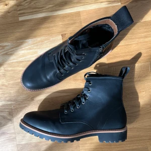 Svarta boots med snörning  - Säljer ett par svarta boots från Madden med grov sula och snörning framtill. Skorna har dragflik baktill med tydlig logga och detaljer i brunt runt sulan. De är använda men i god skick fortfarande!