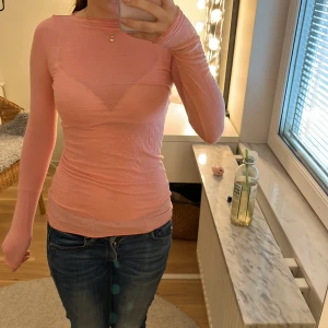 Ljusrosa intimissimi topp - Säljer en tunn, ljusrosa långärmad topp med tight passform. Toppen är enkel och stilren, perfekt att matcha med jeans eller kjol. Materialet känns mjukt och följsamt mot kroppen. Ett litet hål  som man kan se på bild 3 där av de låga priset.