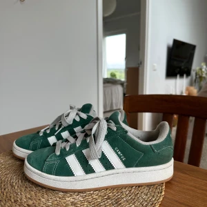 Adidas Campus gröna sneakers - Säljer ett par gröna Adidas Campus sneakers. Skorna har klassisk låg modell, vit sula och är tillverkade i mocka. Endast använda 3-4 gånger så dom är i mycket bra skick!💚 köpta för 1449kr Normala i storleken - passar mig som vanligtvis har 38
