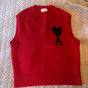 Röd stickad väst AMI PARIS - Röd stickad väst från AMI. Riktigt snygg med skjorta till. Använd väldigt lite då jag inte fått användning för den. Nypris 3799kr.