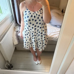 🤍💙Vit kortklänning med blå prickar - 🌞💘Supersöt vit klänning med blå prickigt mönster och volang i nederdelen. Klänningen är ärmlös med smala axelband och har en luftig, lös passform. Perfekt för varma dagar och enkel att styla med sneakers eller sandaler💙🤍💙