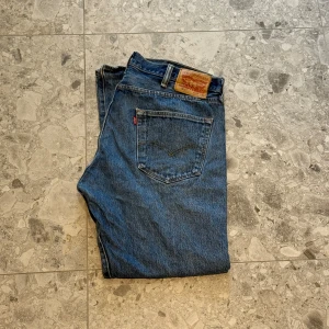 Levi's 501 blå jeans - Klassiska blå Levi's 501 jeans med rak passform. Sjukt snygga jeans enligt mig och är i bra skick. Nypriset ligger på cirka 1400 så ett väldigt bra pris.