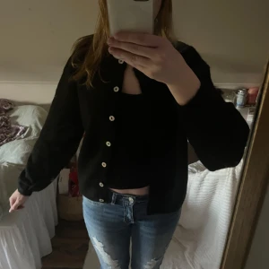 Svart kofta från Gina Tricot  - Svart kofta från Gina Tricot med knappar framtill. Klassisk modell med långa ärmar och enkel design, perfekt att slänga över en topp eller t-shirt. Helt ny ❤️❤️
