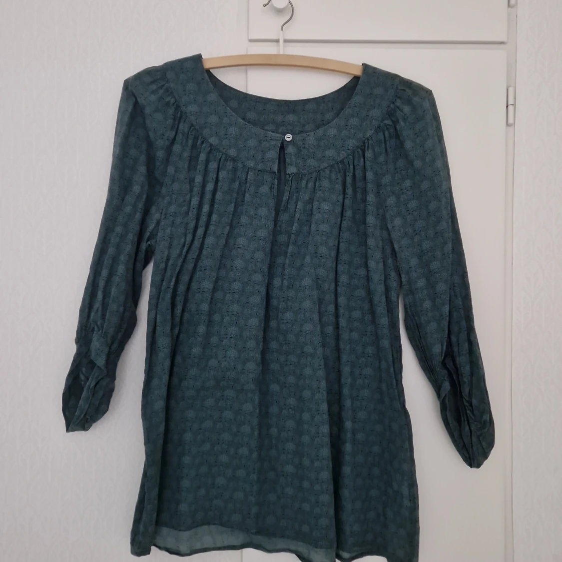 Mörkgrön blus med blommigt mönster från Nygårdsanna