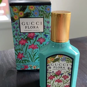 Gucci Flora Gorgeous Jasmine Eau de Parfum 30ml - Gucci Flora Gorgeous Jasmine är en lyxig parfym i en turkosgrön flaska med guldigt lock och blommigt motiv. Doften har noter av jasmin, magnolia och mandarin. Flaskan rymmer 30 ml och är designad med färgstarka blommor och exklusiv känsla.