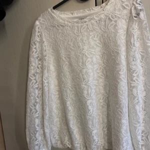 Vit spetsblus från Isolde - Säljer en vit blus från Isolde i genombruten spets med blommigt mönster. Blusen har långa ärmar och rund halsringning. Perfekt för dig som gillar romantisk och feminin stil. Denna hade även varit så fin att sy in!😍