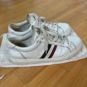 Moncler skor - Säljer mina moncler skor i använt skick, skorna är i storlek 41 men passar även 42. Två stycken dustbags medföljer. Skriv för mer bilder och info!
