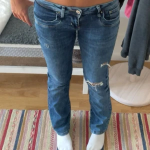 Blå jeans från LTB med slitningar - Snygga blå jeans i från LTB i modellen valerie som har slitna detaljer på låret och knät. Med normal passform och låg midja. Jeansen har en cool, avslappnad vibe och är tillverkade i mjukt denimtyg. Jag använder 27/26 i midja och är 164 lång💗