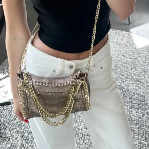 Väska med guldkedjor - Jättesnygg skimmrig väska med guldkedjor. Köpt i Spanien för 600kr, vet ej märket. Har tyvärr fått märken inuti av min läppenna. Utöver det så är den i mycket bra skick!!🤍