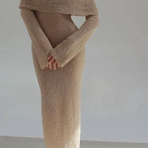 Beige stickad långklänning offshoulder meshki  - Säljer en beige långklänning i stickat material med offshoulder-design och långa ärmar. Klänningen har en unik struktur med små noppor i garnet som ger en cool och trendig känsla. Perfekt för dig som gillar en stilren men ändå speciell look.