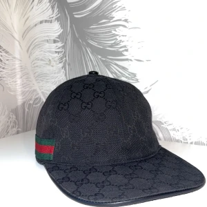 Svart Gucci Canvas Keps - Svart Gucci Canvas keps i storlek M. Kepsen är använd ett par gånger fast är fortfarande i god skick. Med kepsen så ingår en gucci dustbag. Tveka inte att dm:a vid intresse!