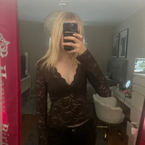 Brun spetstopp från Gina tricot  - Säljer en brun långärmad spetstopp från Gina tricot med v-ringning. Köpt för 300kr. Använd 1 gång. Fint skick. 