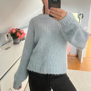 Ljusblå stickad tröja  - Supermysig ljusblå stickad tröja från Ellos med grov ribbstickning och rund hals. Tröjan har en relaxed fit och långa ärmar, perfekt för lager på lager under kyliga dagar. 