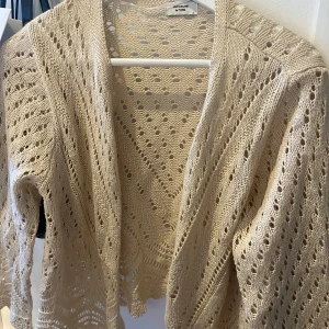 Beige stickad kofta från Jacqueline de Yong - Snygg beige stickad kofta från Jacqueline de Yong med öppet hålmönster och lång ärm. 